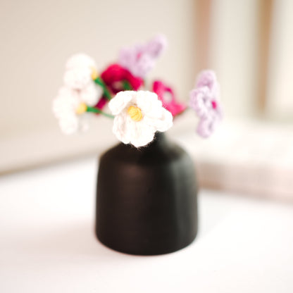 black bud vase with mini crochet daisies